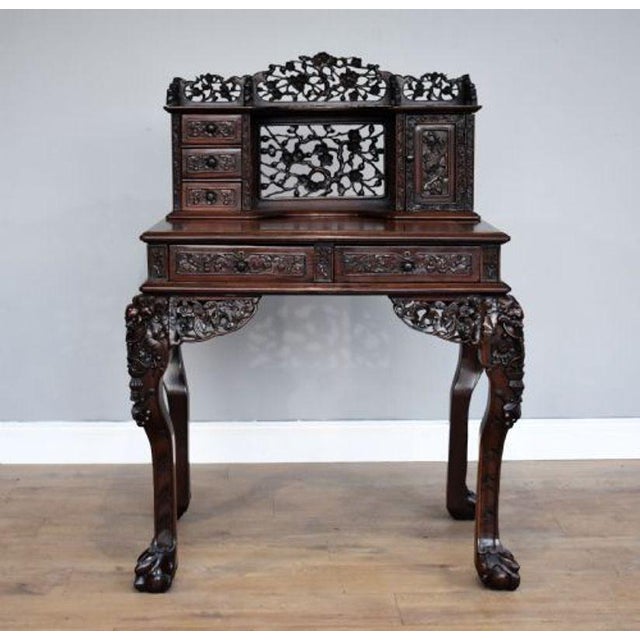 For sale is a good quality 19th century carved Padouk wood desk, having a row of small drawers, and a rectangular door...