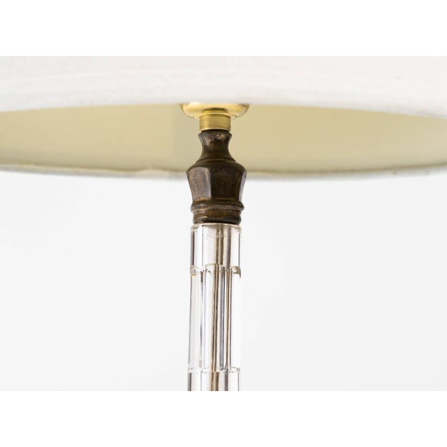 Pair of Art Deco faceted cut crystal lamps with curved circular bases and original patinated brass detail at top.