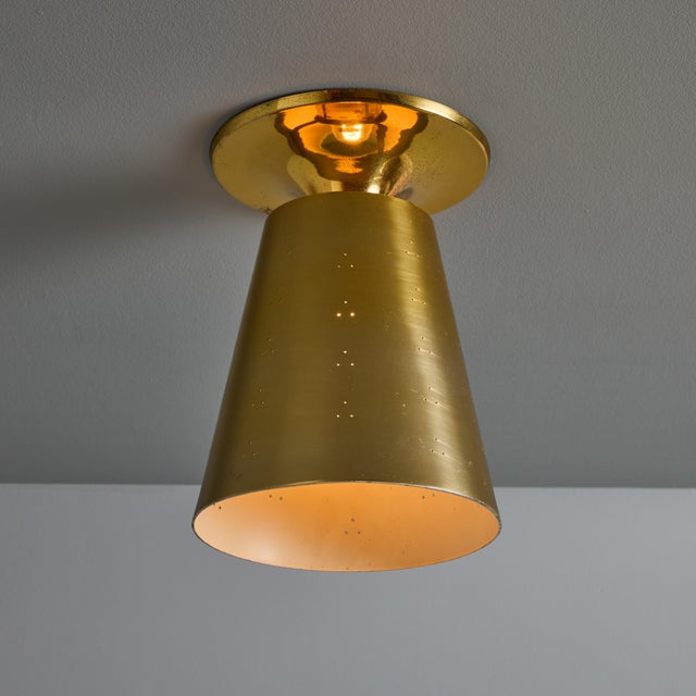 1940s Perforated Brass Conical Ceiling Lamp Attributed to Paavo Tynell. This sculptural semi-flush mount executed in...