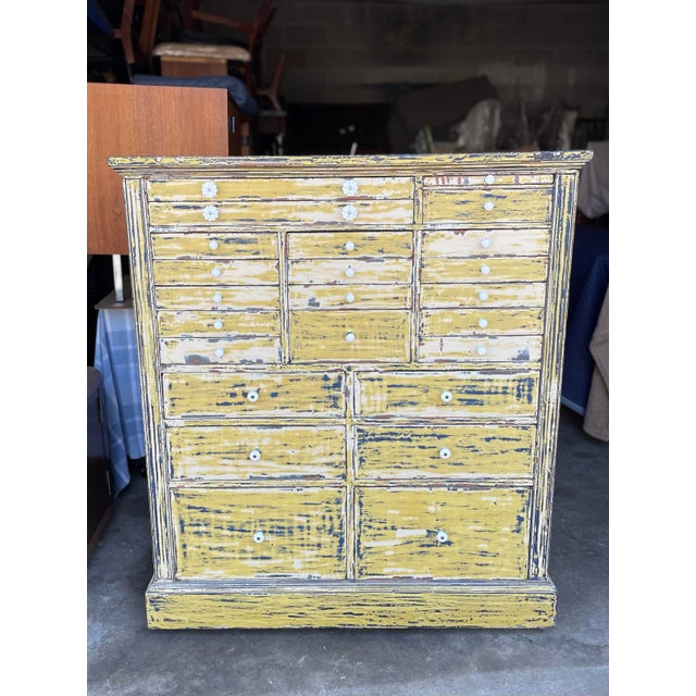 A fabulous solid mahogany painted medical or apothecary cabinet. Shabby chic painted yellow with navy blue paint, with...