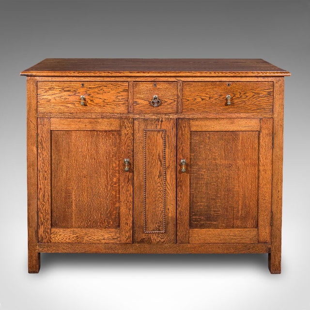 This is an antique dining cabinet. An English, oak and pine sideboard or drinks cupboard, dating to the Edwardian period,...