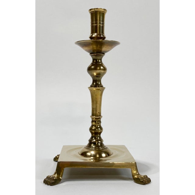 Vintage brass candleholder with exaggerated square base raised by four regal lion paw feet. Lovely patina.