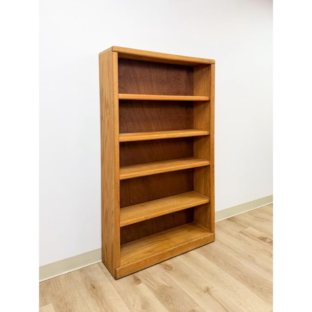 This vintage mid-century bookshelf showcases a clean, light oak finish with softly rounded edges throughout, offering the...