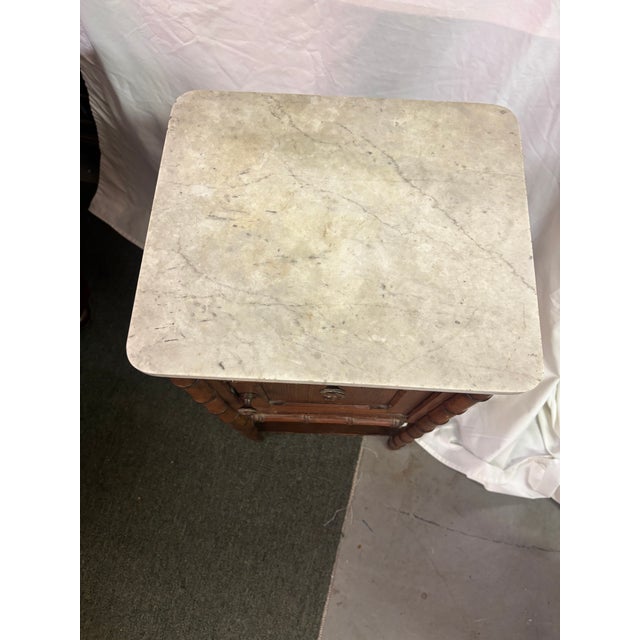 An English Aesthetic Movement Faux Bamboo Marble Top Nightstand, circa 1860-80. the overhanging white marble top above a...