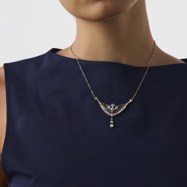 This beautiful Edwardian diamond necklace is a refined antique design from the 1910’s, featuring 3 old European cut...