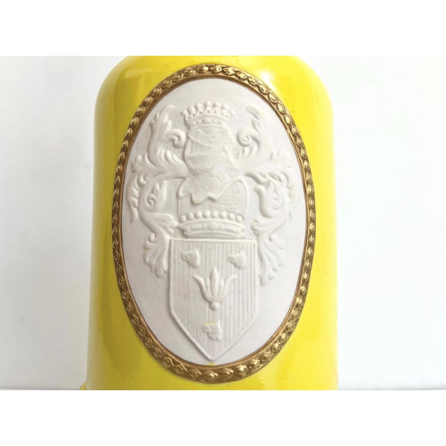 Stunning early mid century heraldry glazed ceramic lamp in saturated canary yellow accented by a central raised knight...