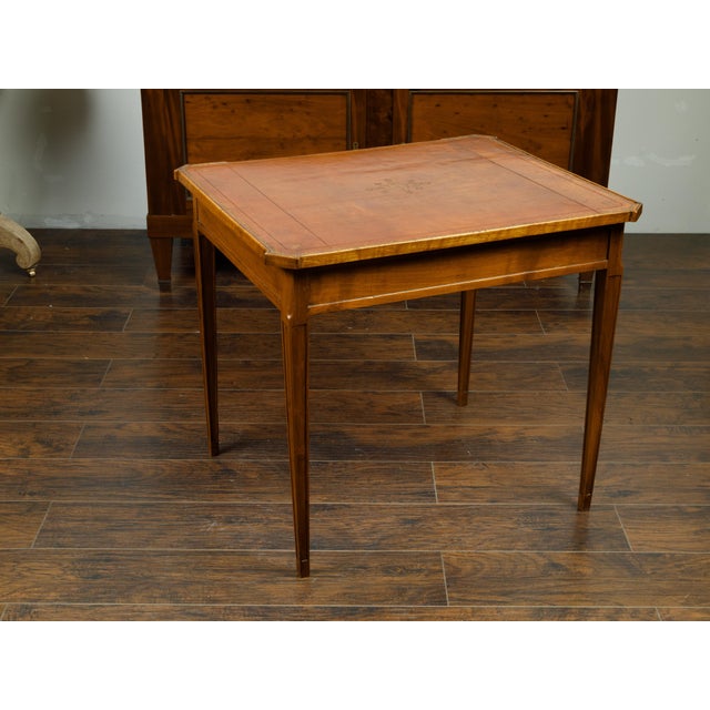 A French walnut side table from the 19th century, with gilt embossed leather top, single drawer and fluted motifs. Created...