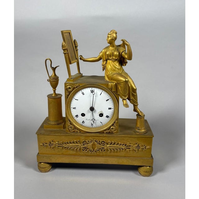 Empire period 19th century mantel clock depicting a woman at her toilette For Sale