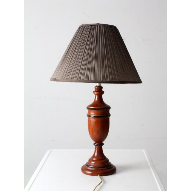 Vintage turned wood table lamp dating to the mid-20th century, featuring a classic American profile with warm, natural...