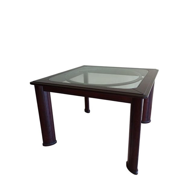 An elegant square table, an example of French Art Deco from the 1960s, featuring polished wood for both the frame and...