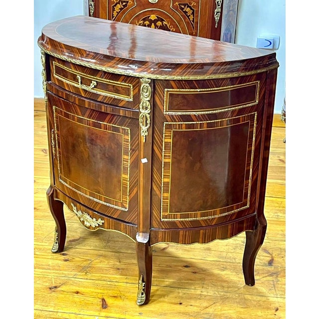 Bring timeless French elegance into your home with this magnificent Louis XVI-style demilune sideboard cabinet. Crafted...