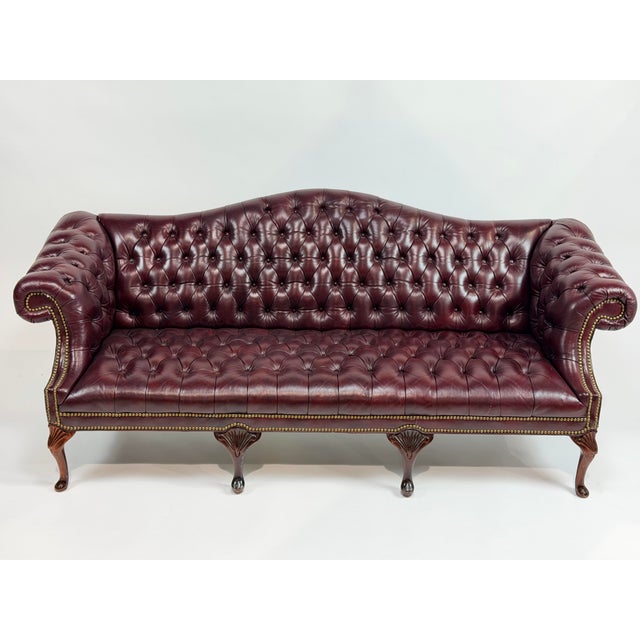 This is a classic 1970s English Chesterfield sofa, upholstered in rich burgundy leather with a beautifully proportioned...