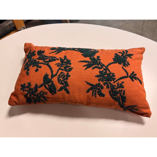 Design Plus Gallery presents a Decorative Lumbar Pillow. This is an orange decorative pillow adorned with embroidered...