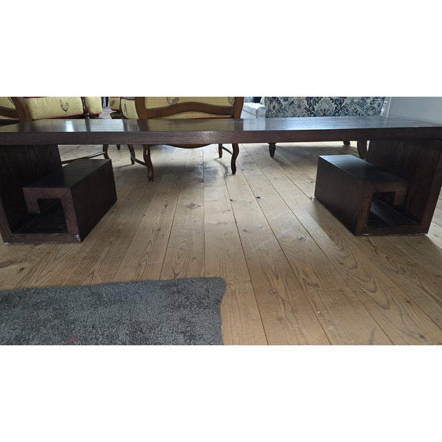Rectangular walnut coffee table featuring a low-profile silhouette and sculptural block base formed from intersecting...