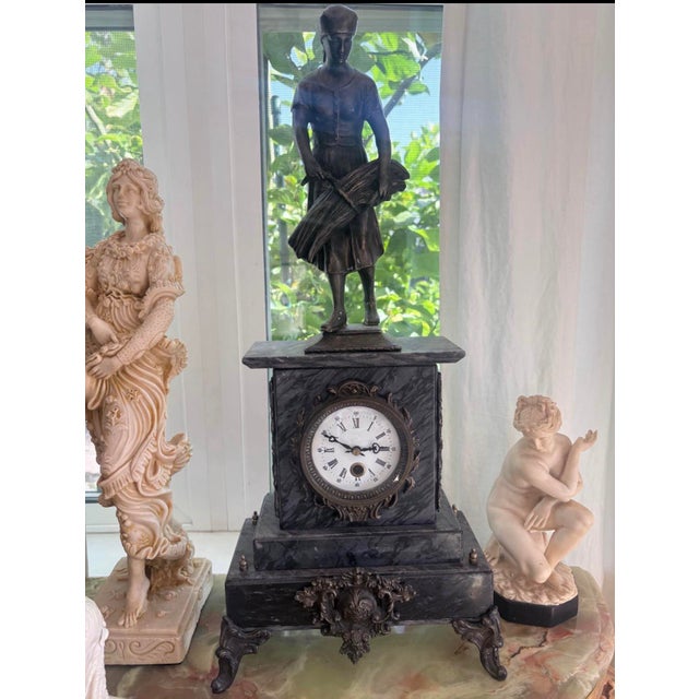 Impressive late 19th-century French mantel clock featuring a richly figured dark marble case surmounted by a patinated...
