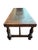 Decorative coffee table in Spanish Colonial Revival style, featuring a richly embossed leather top with stylized pre-...