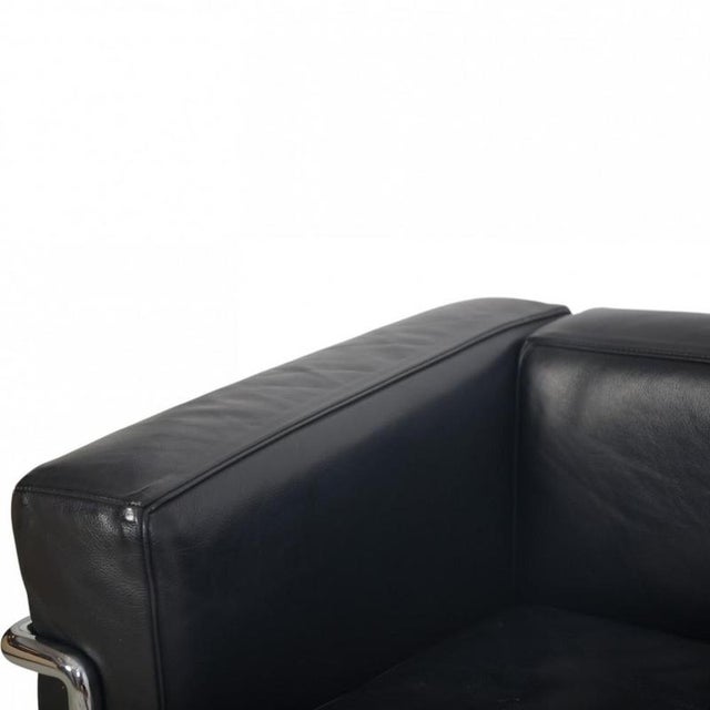 Le Corbusier LC2/3 three-seater sofa upholstered in black pelle leather with a chrome steel frame. The sofa is from the...
