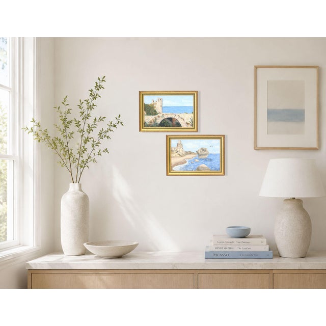 Pair of original French oil on board paintings depicting ancient seaside buildings overlooking a bright blue coastline. A...