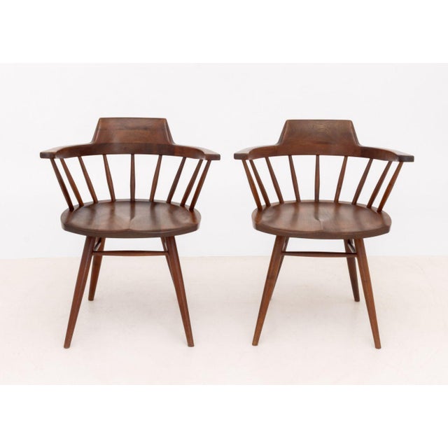 Pair of George Nakashima (American, 1905-1990) American Walnut Captain's Armchairs, 1962, with spindle backs on turned...