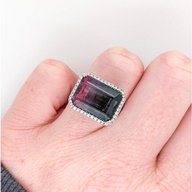 A tourmaline glows in a lively colour at the centre of this solid 14K white gold ring, surrounded by forty earth-mined...