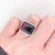 A tourmaline glows in a lively colour at the centre of this solid 14K white gold ring, surrounded by forty earth-mined...