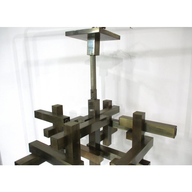 An exceptional bronze toned square tubed metal City Scape chandelier in a cubist style with ten light sockets that can...