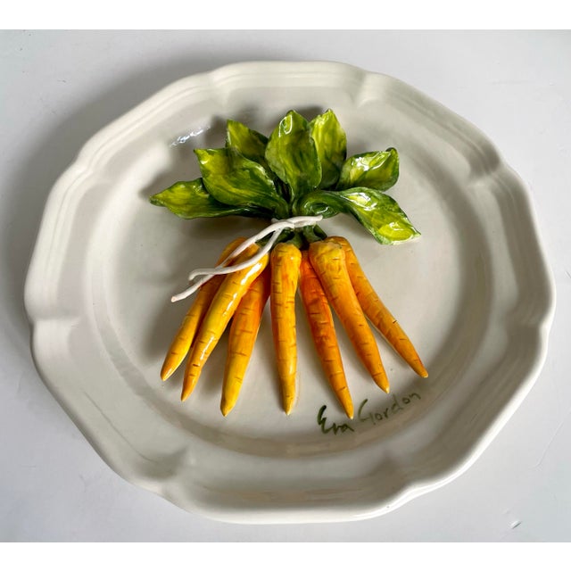 Late 20th century Canadian studio pottery plate by Eva Gordon, featuring a beautifully modeled trompe-l’œil bundle of...