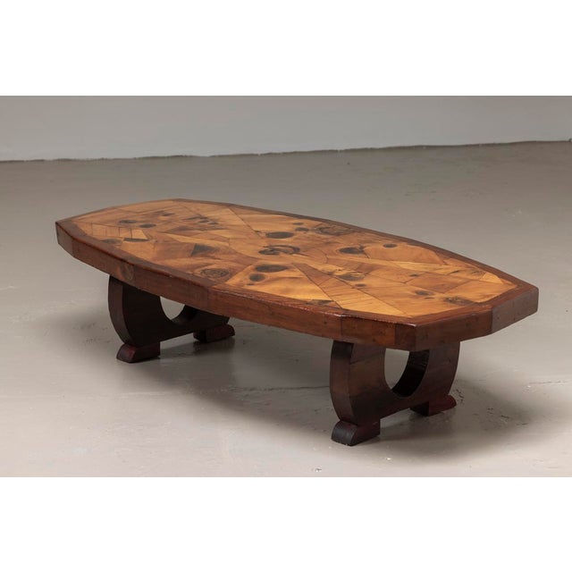 Exceptional coffee table featuring a beautifully geometric inlaid wooden top. In good condition.
