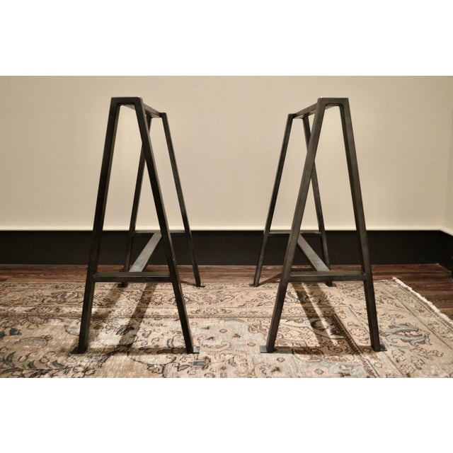 These oxidized steel sawhorse trestle bases were designed by me for a clients dining table and I had a local metal...