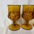 This vintage Indiana Glass amber footed goblet features a classic King's Crown thumbprint pattern and a textured stem.