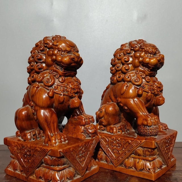 This is an exceptional pair of hand-carved wooden guardian lion statues, traditional symbols of protection, power, and...