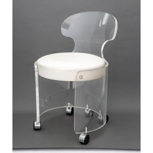 Philippe Starck Style Lucite Vanity Chair, with white leather upholstered cushion on five casters. 26.25" H x 17" W x 18"...