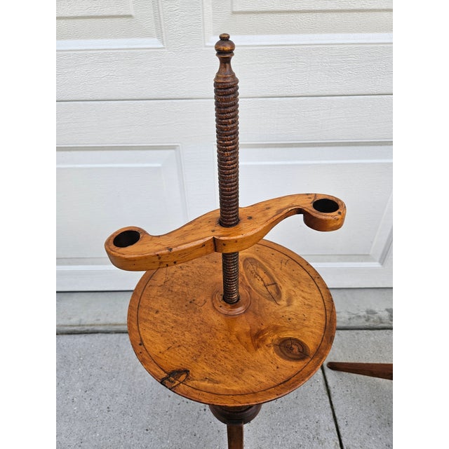 A pair of Colonial style adjustable floor candle stands; the stands feature a threaded central wooden shaft that allows...