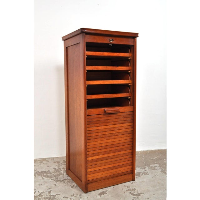 Still in excellent condition after almost 100 years. Beautiful side panels. The oak cabinet has a smoothly running roller...