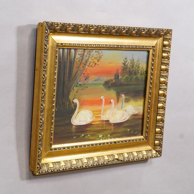 19th Century Painting with Swans on a Lake at Sunset The antique oil painting, presented in a gilded wooden frame, was...