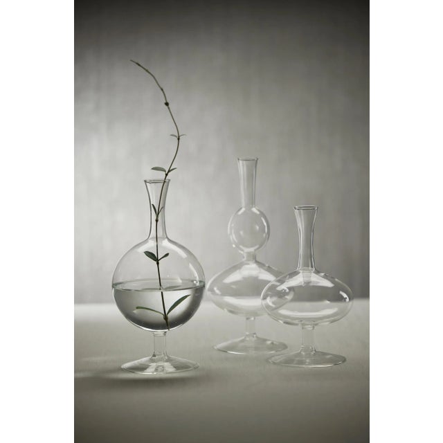 Made out of glass, this set of 2 footed vases are a quaint touch to your home. Its exquisite craftsmanship and eye-...