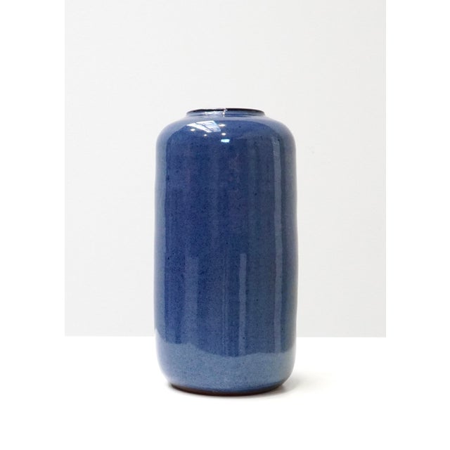A ceramic vase by Belgian ceramist Roger Vandeweghe, defined by its tall cylindrical body and gently rounded shoulders....