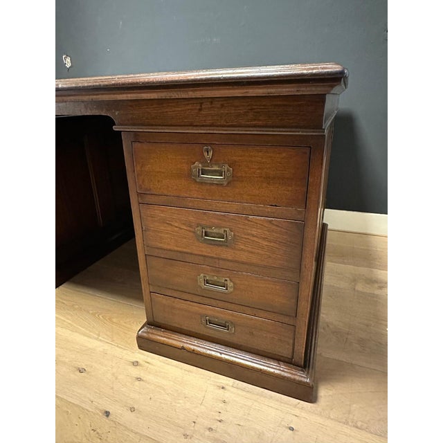 Beautiful antique partner desk in very good condition. The desk has a cabinet on each side and four drawers. It has a dark...