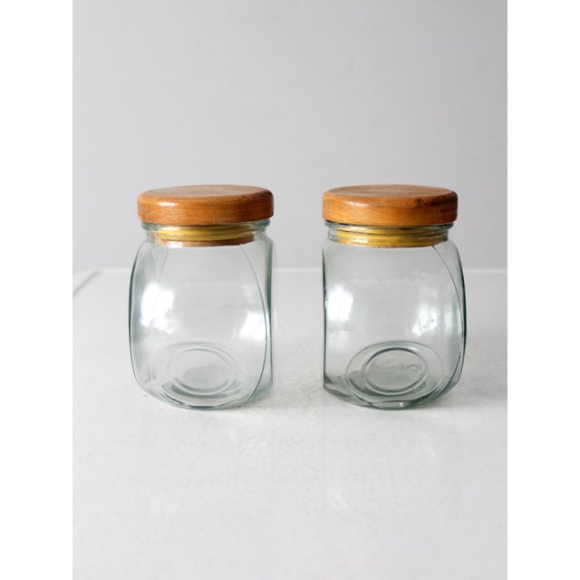 This pair of vintage glass jars offers versatile storage with a timeless design. Featuring a rounded shape with flat...