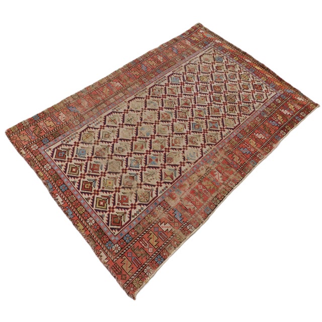 A rare antique Caucasian rug with an allover pattern. Serrated trellises, containing geometric motifs on a cream field....