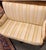A handsome French Restoration period mahogany settee dating to the early 19th century, featuring a finely carved crest...