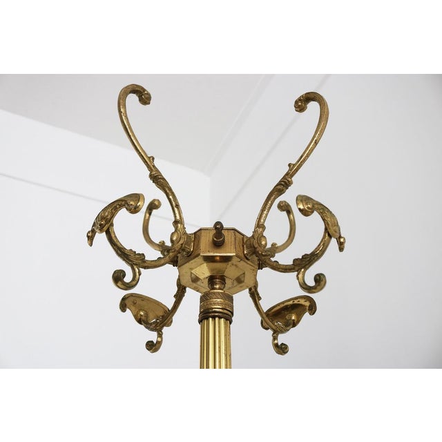 Striking 1960s Italian brass coat rack in classic Hollywood Regency style. The hall tree features a rotating crown at the...