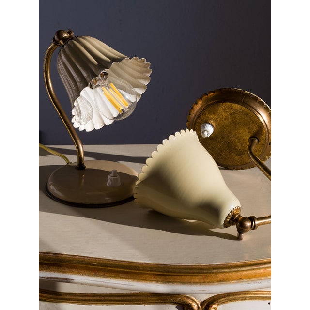 A pair of vintage bedside lamps with adjustable lampshades, Italian design from the 1950s. The brass frame is complemented...