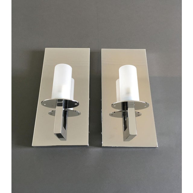 This elegant wall light is totally made in Italy. It has an essential and minimal shape that make it perfectly matching...