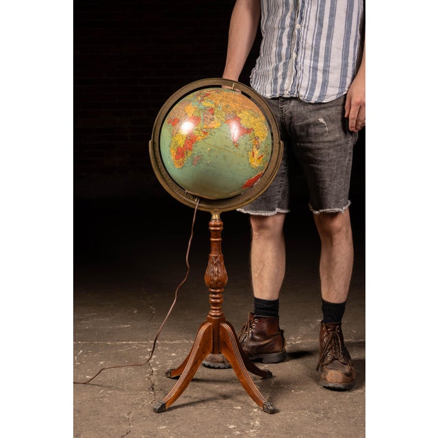 Lighted 12-inch Replogle Library Globe mounted within a cast metal meridian and supported by a turned and carved oak...