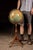 Lighted 12-inch Replogle Library Globe mounted within a cast metal meridian and supported by a turned and carved oak...