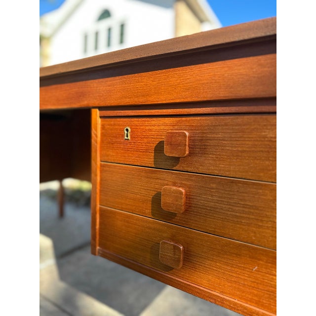 A beautifully crafted Danish mid-century teak desk by Domino Møbler, dating to approximately the 1960s. Featuring a warm...