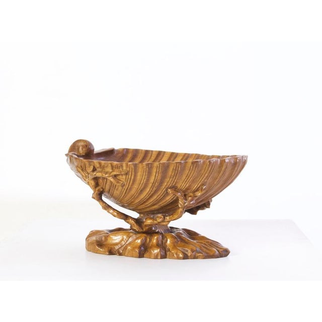 A large hand carved olive wood bowl in the shape of a clam shell. Great for decorative purposes or as a fruit bowl. No...