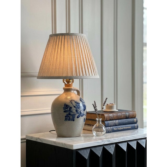 An exceptional example of American folk art craftsmanship, this vintage salt-glazed stoneware jug table lamp was...