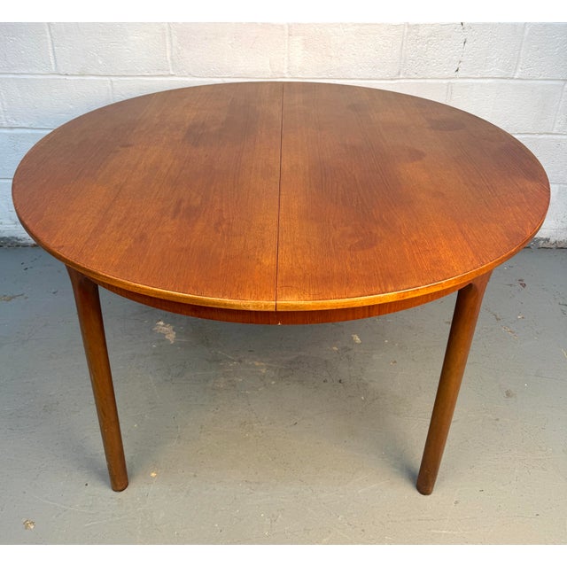 Elegant mid-century modern circular dining table crafted from beautifully grained teak by A.H. McIntosh & Co. of...